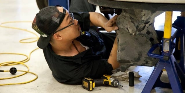 man under car repairing it