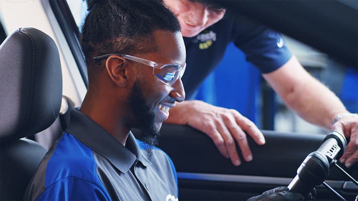A J-Tech Automotive Technician student working with a diagnostic tablet in the lab.