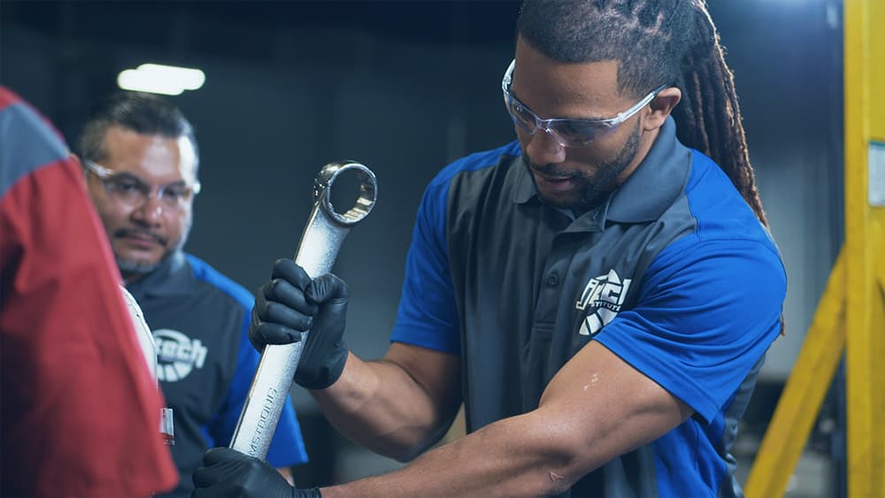 A Diesel Technology student working hands-on with huge equipment.