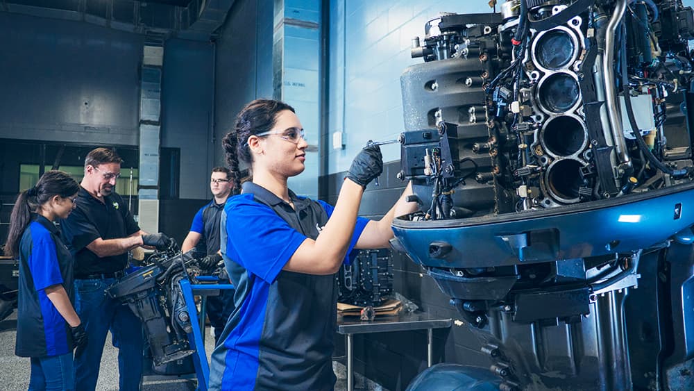 A Marine & RV Technology student tuning an boat engine in the new Marine & RV lab.