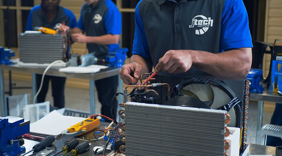 J-Tech students working hands-on with soldering irons in the HVAC-R lab.