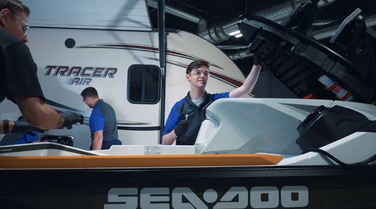 J-Tech students working hands-on with jet skis and campers in the Marine & RV Technology lab.