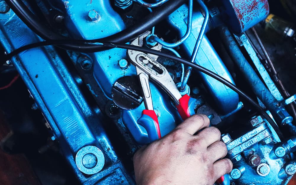 Close-up of a wrench tightening a bold on a marine engine.