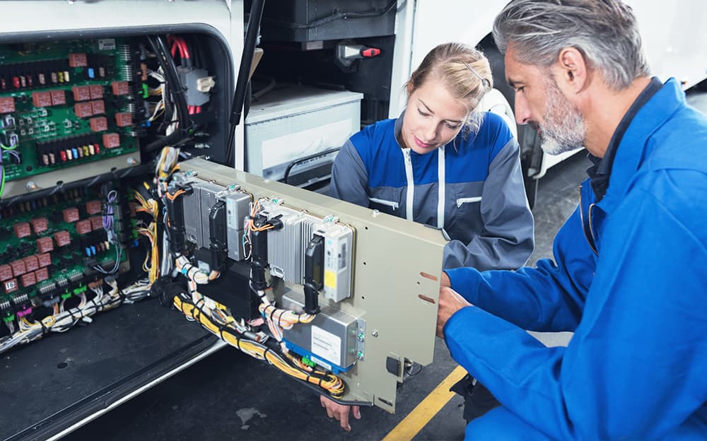 RV mechanics checking the electrical systems in a camper van.