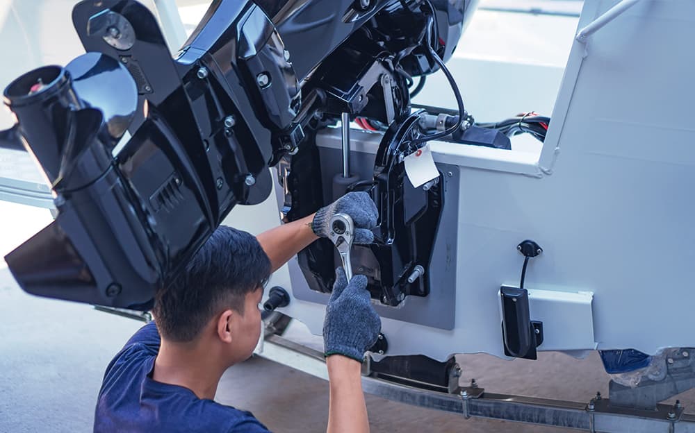 Marine technician working an outboard engine.