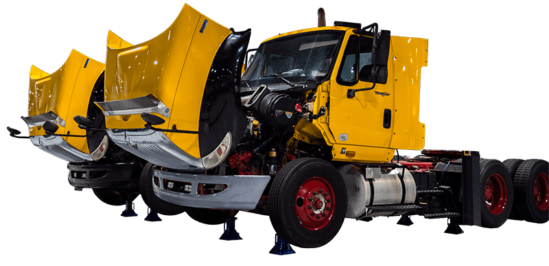 Diesel trucks with their hoods open, ready to be worked on.