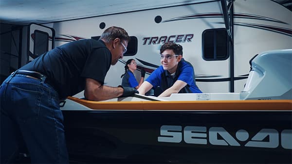 A J-Tech Marine & RV Technology student working alongside his instructor on a Sea Doo jetski.