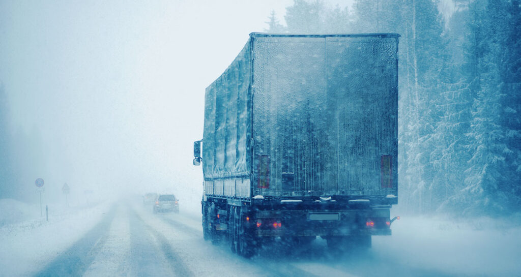 A Semi-Truck in a Snowstorm on an Icy Road.
